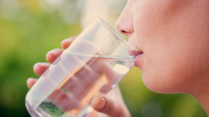 Eine Frau trinkt Edelsteinwasser